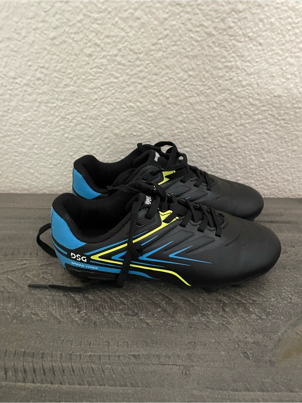 DSG Black soccer cleats with Blue and Yellow Trim